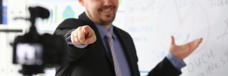 Male in suit and tie show stats graph pad making promo videoblog or photo in office camcorder to tripod portrait. Vlogger selfie solution or finance advisor management information professional conceptの写真素材