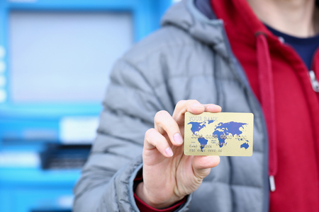 Male hand hold bank plastic card aganist atmの写真素材