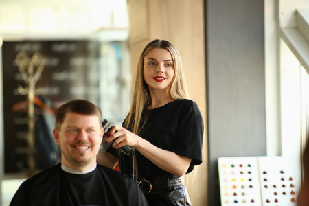 Young Girl Hairstylist Shave Smiling Male Clientの写真素材
