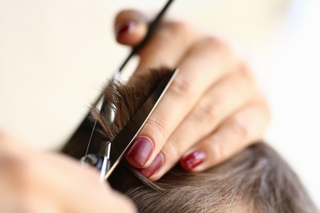 Female Fingers Trimming Male Hair by Scissorsの写真素材
