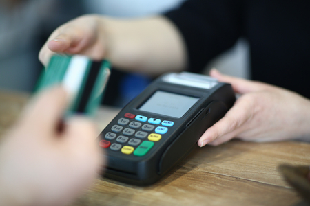 Cashier Hand Taking Plastic Credit Card to Paymentの写真素材