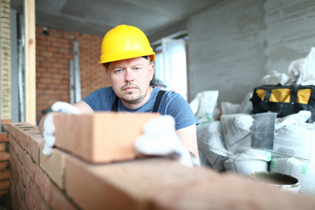Concentrated man with brickの写真素材