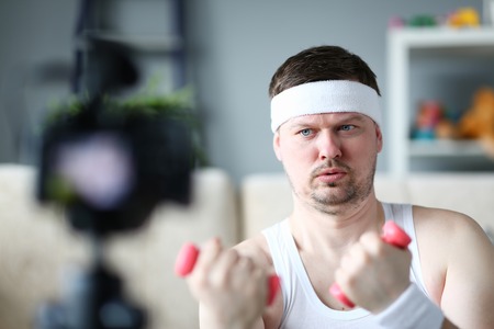 Serious Vlogger Doing Exercise with Dumbbellsの写真素材
