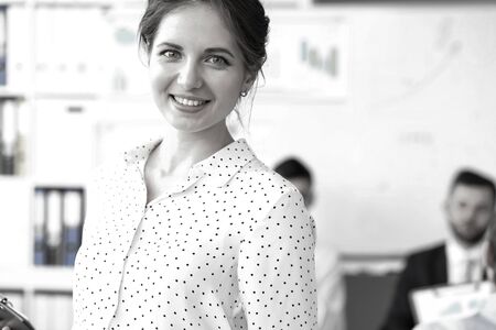 Young beautiful smiling clerk in office looking in cameraの写真素材