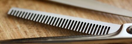 Thinning shears lie on wooden table