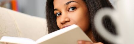 Smiling black woman read story book at home