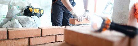 Male builder hand in gloves holding