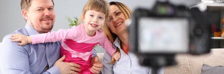Young happy family sit on couch making photo session portrait