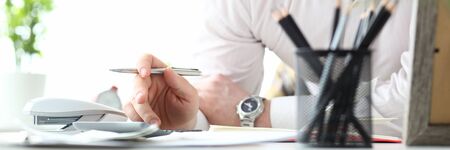 Mature man working with calculator evaluating financial opportunities for family vacationの写真素材