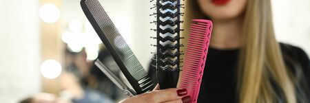 Beautiful Hairdresser Showing Comb and Scissorsの写真素材