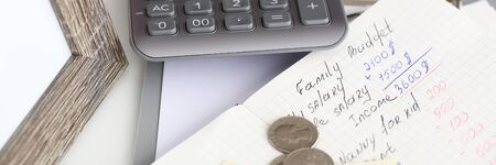 Family financial statistics written on notepad page lying on tableの写真素材