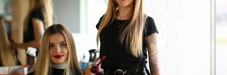 Young Blonde Hairstylist and Salon Female Client