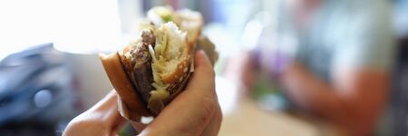 Male hand hold teasty burger in hand aganistの写真素材