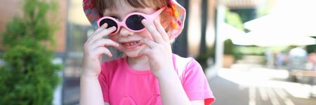 Happy smiling girl child in sunglasses outdoor portrait. Childhood concept.