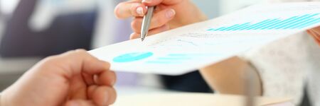 Female hand showing financial report paper to customer closeup