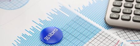 Libra blue cryptocyrrency coin lie on table against