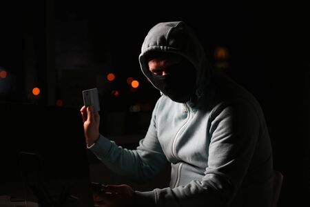 Man carder in mask connect to darknet search information bank system pc crack dark web uses stolen credit card cloud buy illegal servicesの写真素材