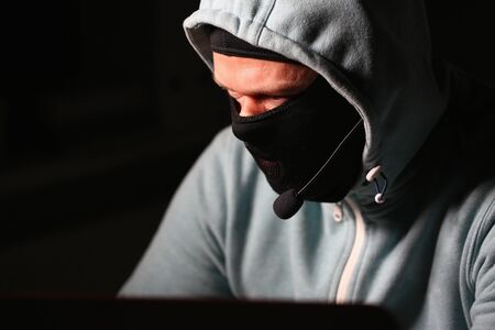 Man carder in mask connect to darknet search information bank system pc crack dark web uses stolen credit card cloud buy illegal servicesの写真素材