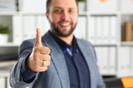 young handsome promising businessman work in office lend hand ahead show big finger up all right conceptの写真素材