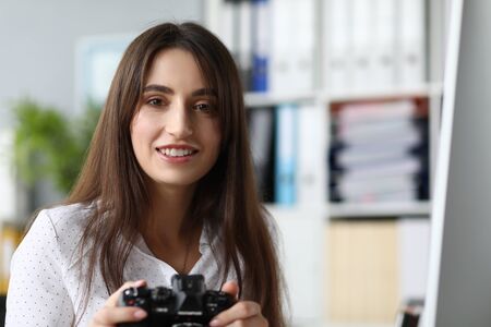 Portrait of smiling woman taking photograph. Beautiful photographer looking at camera with happiness. Business and art design concept. Blurred backgroundの写真素材