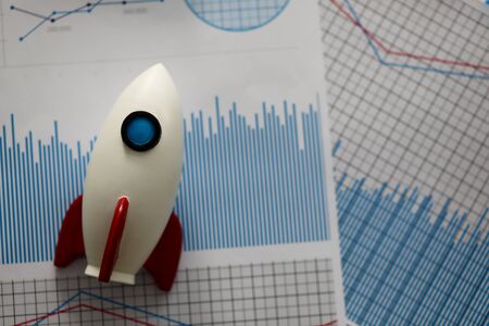 White rocket against business chart background. Fast startup conceptの写真素材