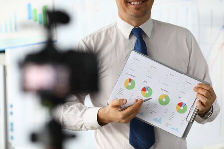 Male hand hold clipboard with business chart closeup. Online workshop broadcast. Webinar for business people concept.の写真素材