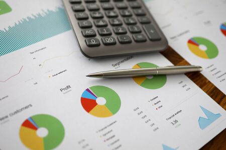 Focus on biz document with charts, graphs, pen and calculator. Important paper with annual report of increased productivity and employee progress. Business and financial conceptの写真素材