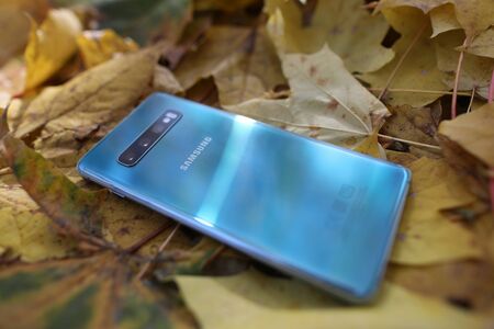 Minsk, Belarus - Oktober 16, 2019 : Samsung galaxy s 10 plus on yellow fallen foliage. Illustrative...