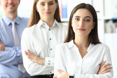 Portrait of smiling lady standing with businesspeople together. Joyful businesswoman standing at...