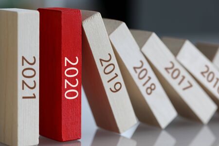 Business power 2020 concept. Unique red block holds domino effect. Stopping globalization in world