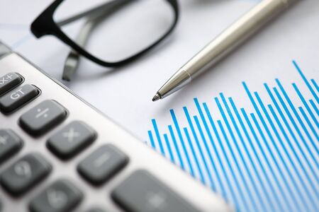 Silver pen gray calculator with paper chart and glasses lie in office table closeup. Business education conceptの写真素材