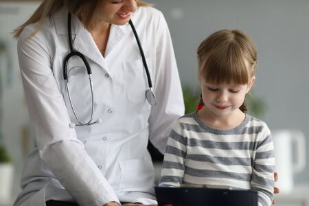 Female doctor exam child patient in hospital office portrait. Medical baby treatment conceptの写真素材