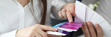 Focus on male and female hands holding colored palette. Trendy creator in white blouse pointing at suitable colour with tender hands to coworker. Art design conceptの写真素材