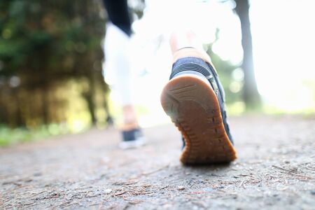 Close-up of male foot in sports sneakers. Runner doing sport and physical exercises in park alone. Special and comfortable running shoes. Healthy lifestyle and fitness conceptの写真素材