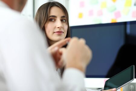 Beautiful caucasian employee discussing job with male coworker at office workplace headshot
