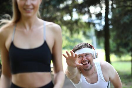Focus on tired man wearing sportswear and sports dressing. Cheerful sportsman doing sport, having...