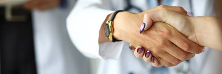 Arm of female GP shaking hands with visitor close-up. Self introduction cheering or problem solution deal conceptの写真素材