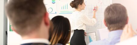 Portrait of pretty woman explaining important business strategy that can determine future of colossal corporation. Smart colleagues sitting in big modern office and work. Company meeting conceptの写真素材