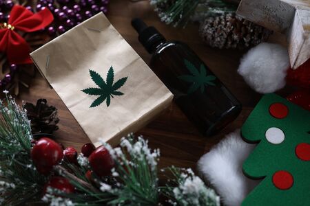 Eco paper pack with green marijuana sign with christmas symbol background closeup. Legal drug conceptの写真素材