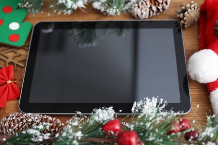 Close-up of black tablet with empty copy space surrounded with christmas decoration. New year...