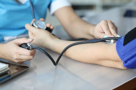 Focus on hands of therapist holding tonometer. Experienced doctor applying medical equipment for...
