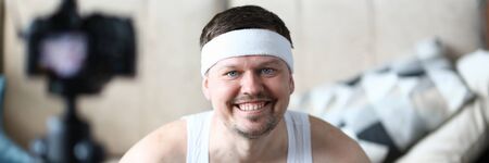 Smiling Vlogger Recording Fitness Video on Camera. Happy Bearded Man Shooting Video for Sport Vlog in Apartment. Guy Practice Healthy Lifestyle. Cheerful Sportsman Head and Shoulders Portraitの写真素材