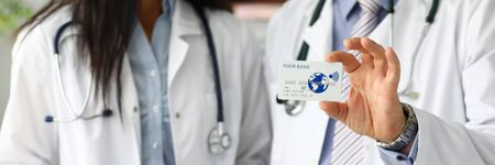 Two doctors showing plastic card in camera close-up