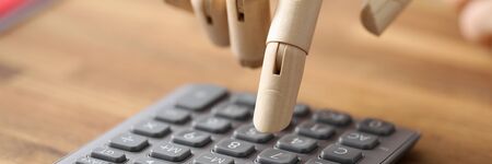 Close-up of person with prosthesis hand calculating. Businessman accounting budget. People with...