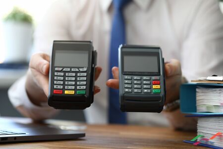 Male businessman hand hold two wireless device pos terminal closeup.の写真素材