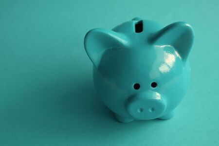 Stylish modern piggy bank on a turquoise background closeupの写真素材