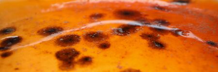 Sowing penicillin mold on an orange sugar substance closeup background. Chinese coronavirus concept
