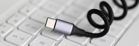 Usb type c cable against laptop keyboard background. Fast charge concept