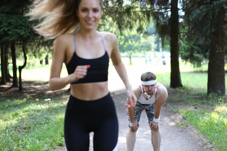 Man and woman on morning run in summer park. Cardio training is aimed at strengthening heart and...