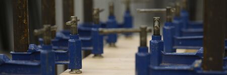 New metal utilities used on carpentry workbenches for wood crafting works in big rusty workshop openfield factory. Manual manufacturing process conceptの写真素材